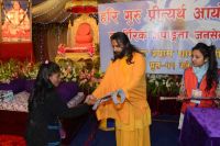 Swamiji distributing assistive devices and necessary equipments to differently abled people